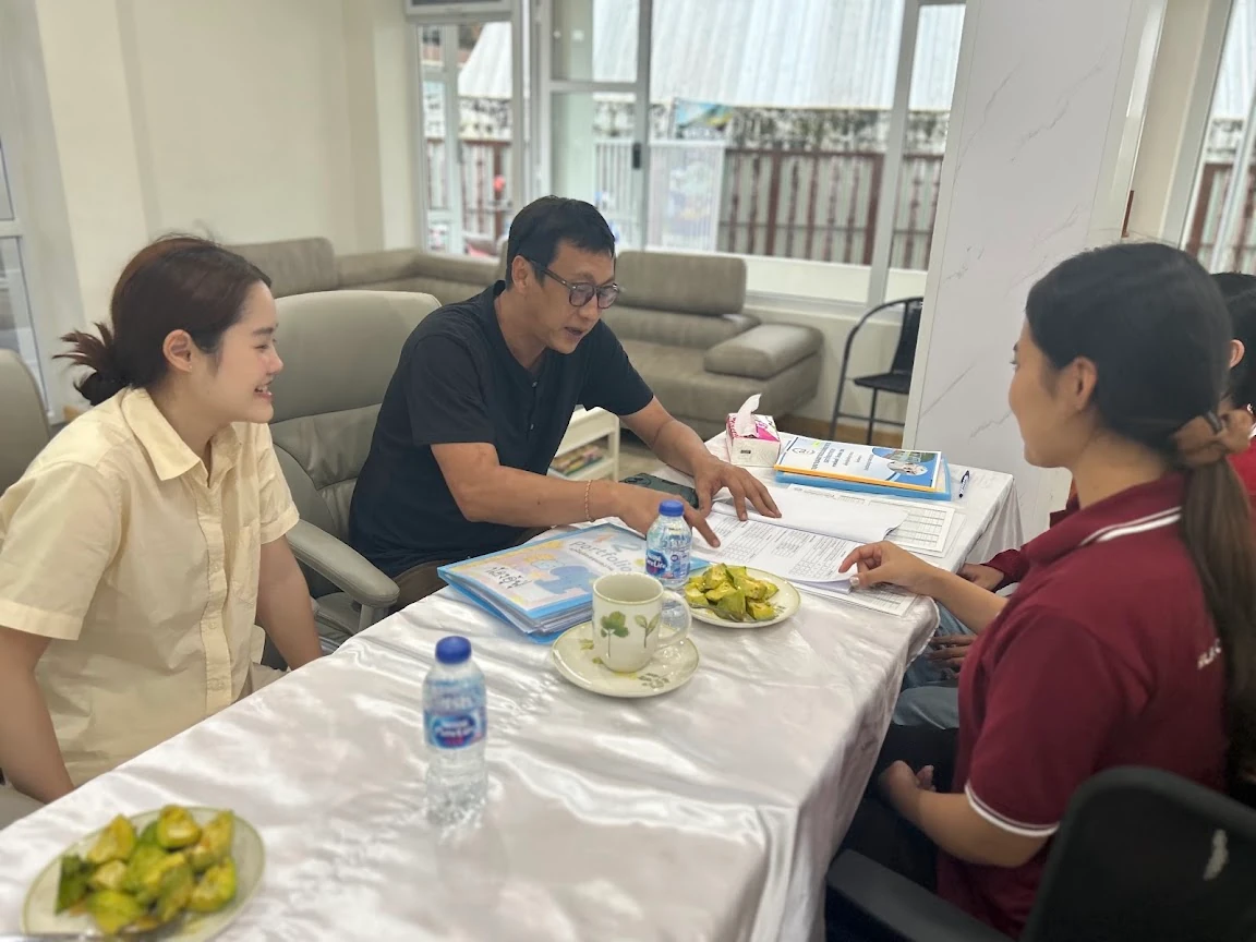 到访学校的家长隔着桌子与 SiLA 老师交谈