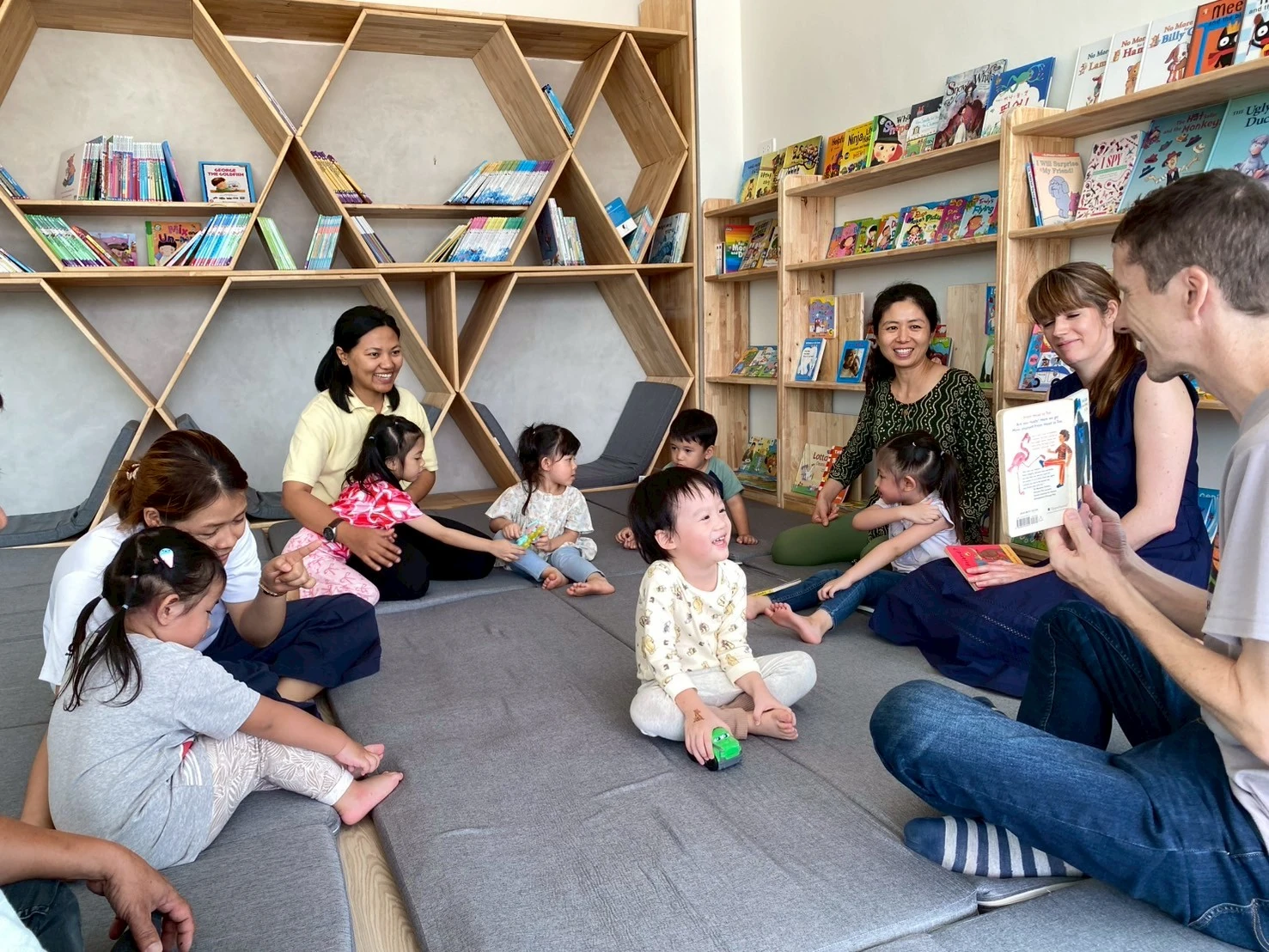 Teachers and families sharing a storybook with children during Storytelling Time
